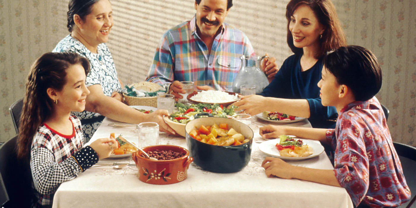 A family gathered around a table sharing a meal together